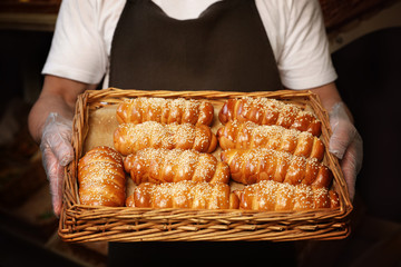 Baker with tray of fresh buns in store, closeup
