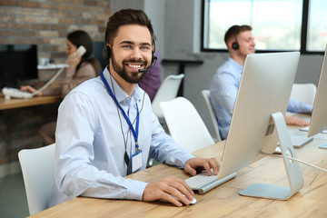 Technical support operator working with colleagues in office