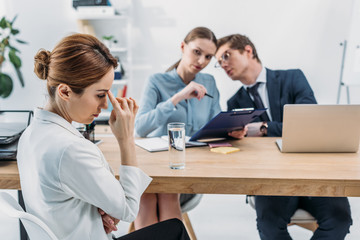 selective focus of upset woman near recruiters on job interview
