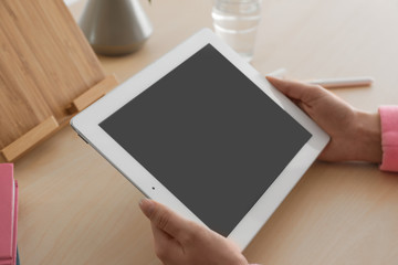 Woman using tablet at table, closeup. Space for design