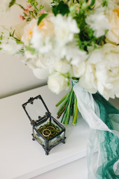 Wedding rings near wedding bouquet