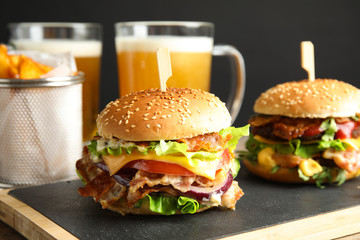 Tasty burgers with bacon served on board