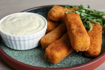 Plate of tasty cheese sticks and sauce, closeup