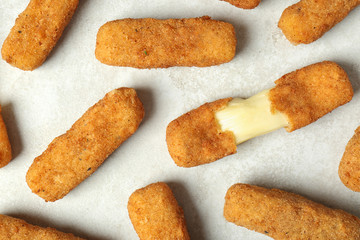 Tasty cheese sticks on grey background, top view
