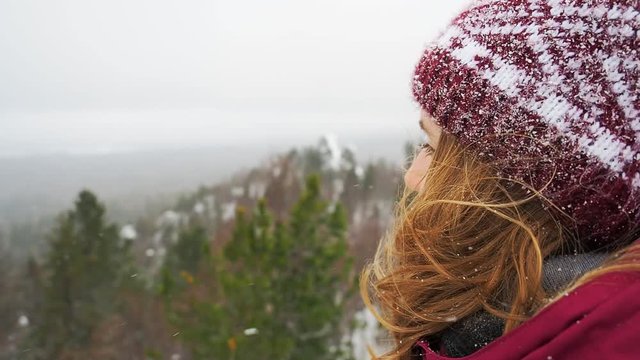 Woman backpacker in a winter hike snow forest trail national par Young girl enjoy snow falling . Happy winter holidays active lifestyle concept.