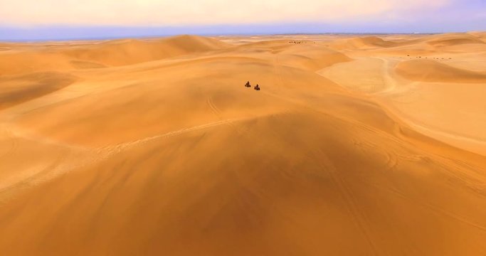 NAMIB-NAUKLUFT NATIONAL PARK, NAMIBIA. Drone footage of famous African landmark. Top aerial view of adults riding within dune fields.