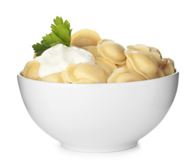 Tasty dumplings with sour cream and parsley in bowl isolated on white