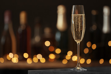 Glass of champagne on table against blurred background. Space for text