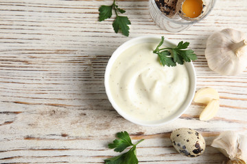 Flat lay composition with garlic sauce on wooden background. Space for text