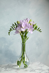 Bouquet of fresh freesia flowers in vase on table