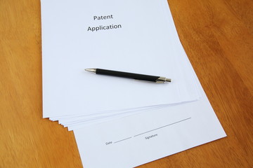 Patent application and pen on wooden table