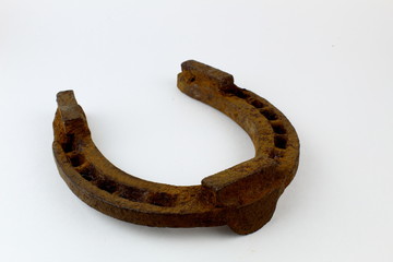 Old rusty horseshoe on a light background. Symbol of good luck and luck.