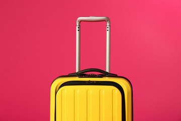 Stylish carry on suitcase on color background