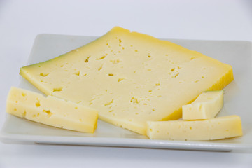 Formaggio Asiago su piatto e sfondo bianco