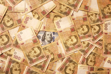 Fototapeta na wymiar The American dollar is strewn with Ukrainian hryvnia. Portrait of Benjamin Franklin surrounded by Ukrainian banknotes. Money background