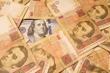 The American dollar is strewn with Ukrainian hryvnia. Portrait of Benjamin Franklin surrounded by Ukrainian banknotes. Money background