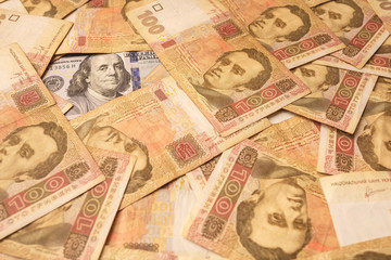 The American dollar is strewn with Ukrainian hryvnia. Portrait of Benjamin Franklin surrounded by Ukrainian banknotes. Money background
