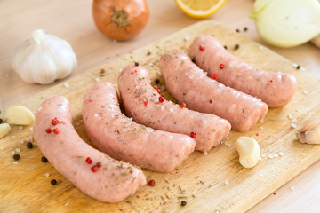 raw pork sausages with spices and garlic on the cutting Board