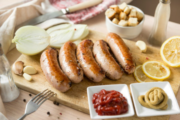 fried pork sausages with onions, garlic, ketchup, mustard on the cutting Board ,