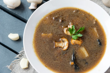 mushroom soup in a white plate, mushrooms, garlic