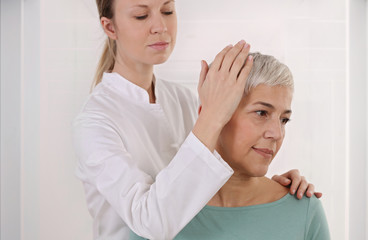 Fototapeta premium Mature Woman having chiropractic back adjustment in rehabilitation clinic. Osteopathy, Physiotherapy concept