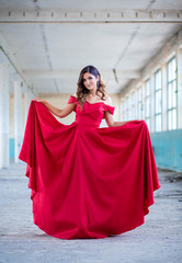 Beautiful teen girl in long, glamorous red dress going to her prom or dance