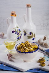 Grilled olives with garlic, olive oil and spices on rustic wooden background