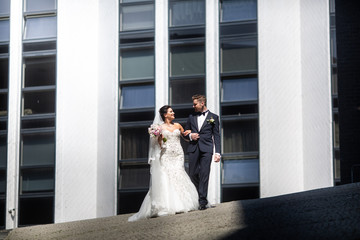 Bride and groom walking in the city, wedding day, marriage concept. Bride and groom in urban...