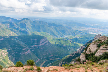 Mountains near Montserrat Abbey in Spain. Clouds and fog. Trees on cliffs.