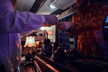 Chinese tea ceremony. Tea master in kimono with a girl during a Chinese tea ceremony in the dark room with a wooden interior.