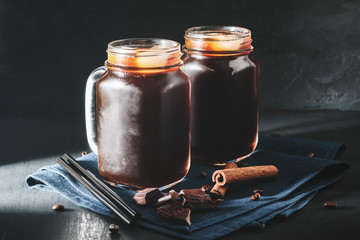 Coffee with ice in a glass mason jars on the napkin at dark background