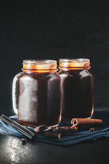 Coffee with ice in a glass mason jars on the napkin at dark background