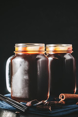 Coffee with ice in a glass mason jars on the napkin at dark background