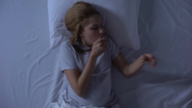 Sick pregnant woman suffering from nausea lying bed, toxicosis symptom, health