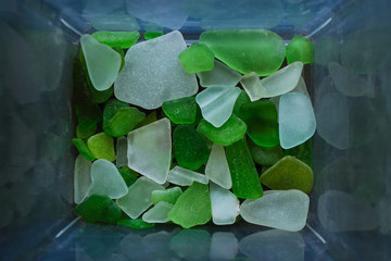 Broken glass from the sea of many colors and sizes are found on our shelling beaches. Top view, marine concept.