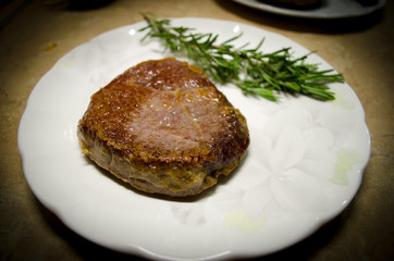 Roasted beef steak on the plate with green rosemary