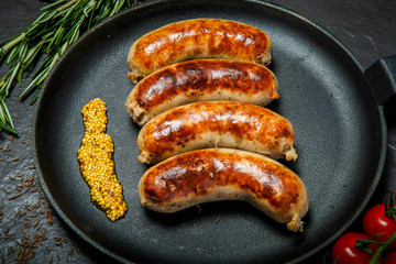 top view closeip fried sausages on round pan with granular mustard