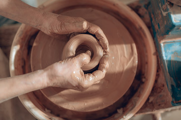 Top view of female hands shaping bowl at workshop