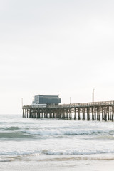 Fototapeta na wymiar Waves in the Pacific Ocean and the pier in Newport Beach, Orange County, California