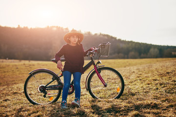 Obraz premium Cute little ten year old girl riding bicycle on countryside.
