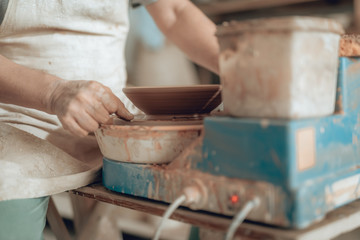 Close up of craftsman working on potter's wheel in his workshop