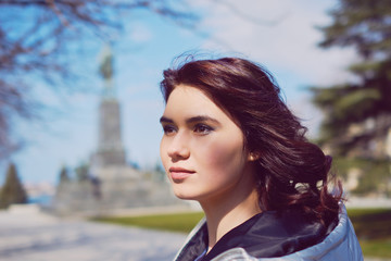 Naklejka premium Young brunette walking in a park in spring