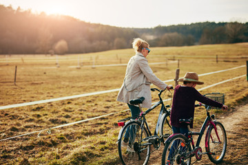 Fototapeta premium Mother and daughter with bicycles on countryside.