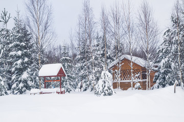 Wooden gazebo at a private house in the winter near the forest