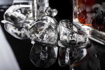 Tube shaped ice on a black table. Melted ice cube on the kitchen table.