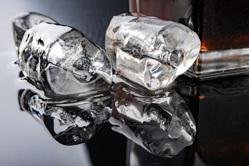 Tube shaped ice on a black table. Melted ice cube on the kitchen table.