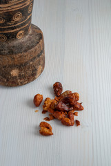 Close-up of old mortar with cayenne on white wooden background