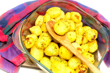 The baked potatoes in a baking tray close-up