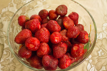 Red juicy ripe strawberry in a glass bowl