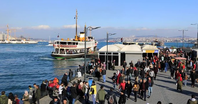 A lots of people in Eminonu pier and traditional passenger ship. Eminonu, Istanbul, Turkey. Time lapse
